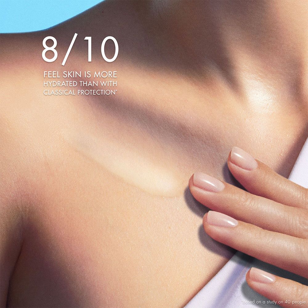 Gros plan sur le cou et l'épaule d'une personne. Texte : Feel skin is more hydrated than with classical protection.