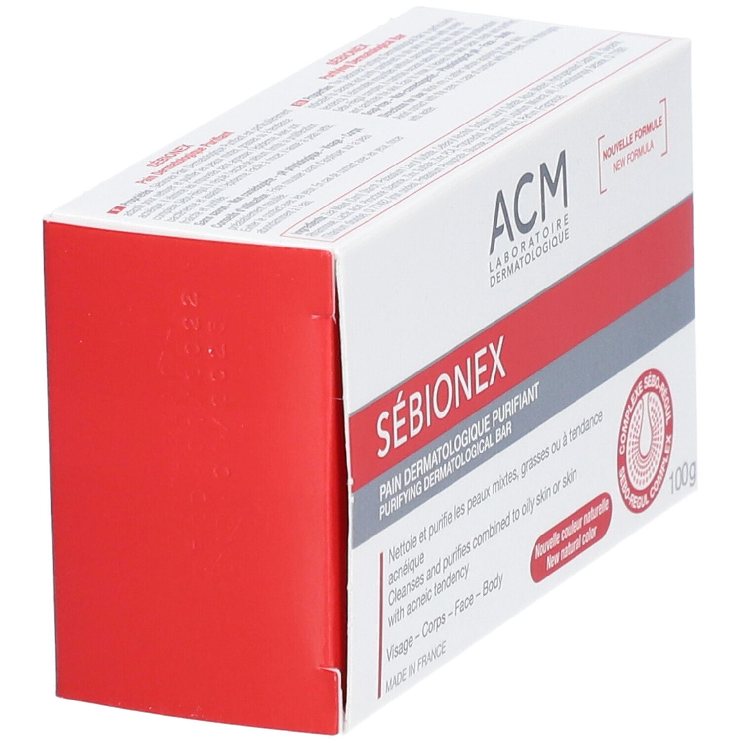 Schuin geplaatste verpakking van ACM Sébionex Pain dermatologique purifiant. Wit-rode doos met productnaam en logo.