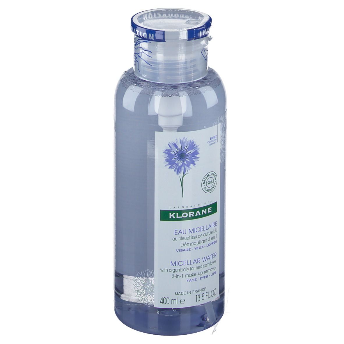 Flacon transparent avec liquide bleu. Étiquette avec nom du produit et illustration de bleuet. Bouchon avec bande bleue.