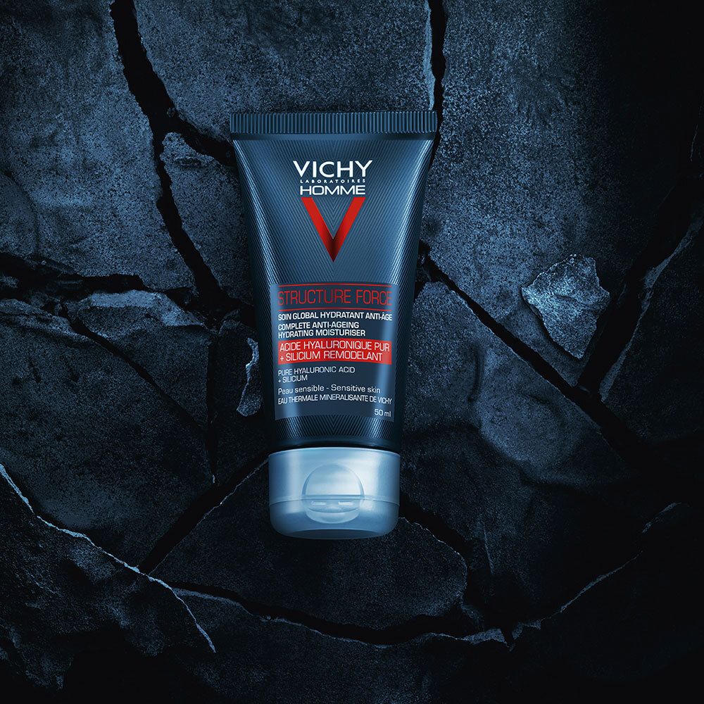 Schwarze Tube mit VICHY Homme, rotem V und Text. Auf Steinmuster platziert.