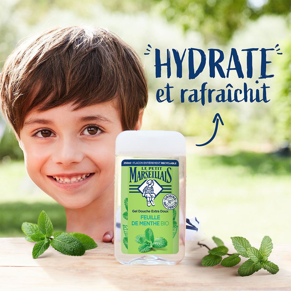 Junge lächelt neben dem Duschgel. Aufschrift: Le Petit Marseillais, Feulle de Menthe Bio. Text: Hydrate et rafraîchit.