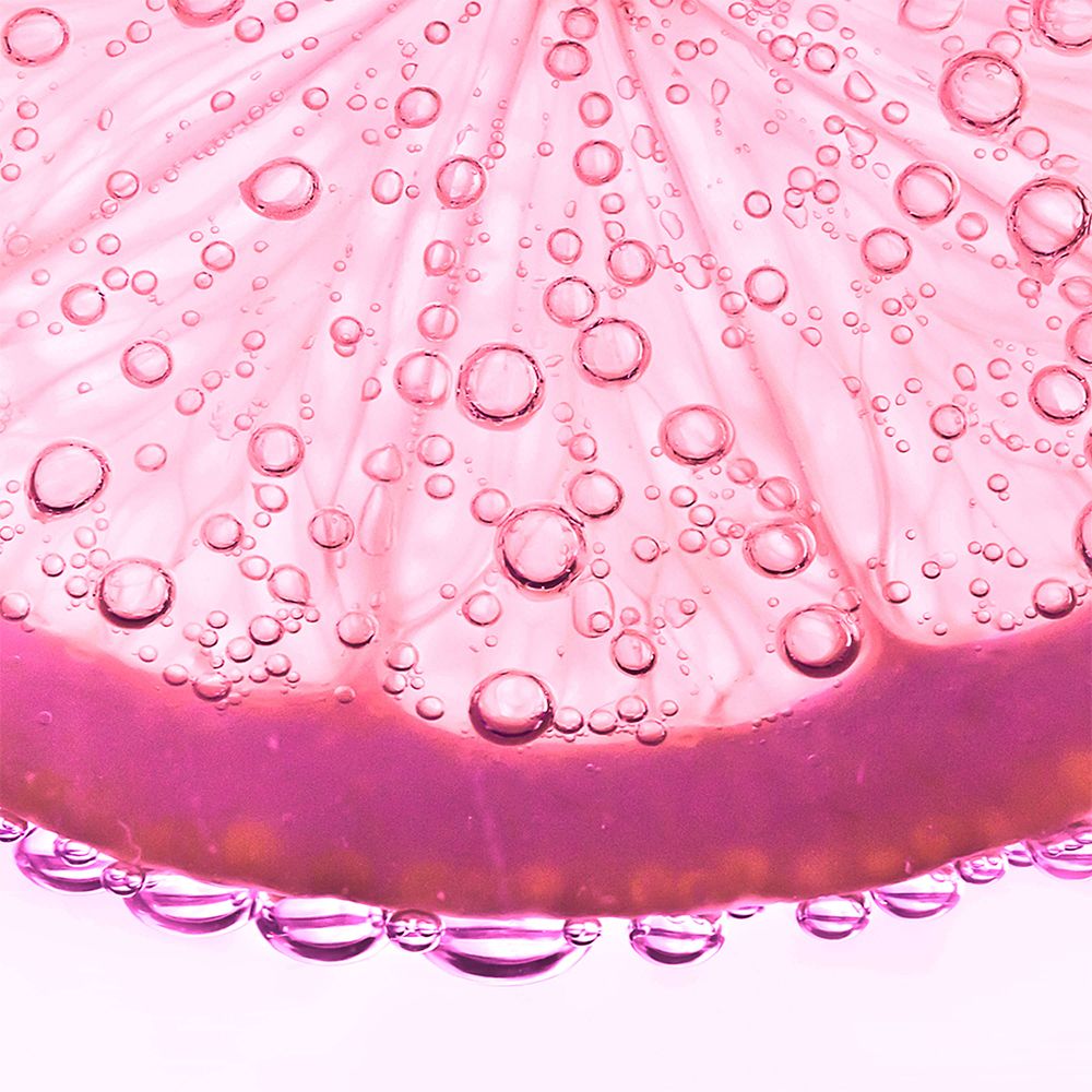 Nahaufnahme einer rosa Zitronenscheibe mit Blasen.