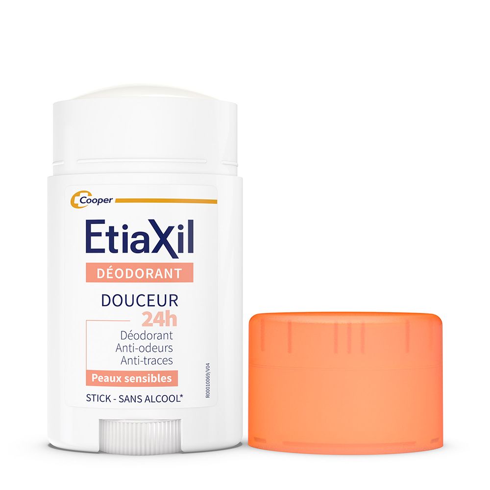 Stick déodorant blanc avec bouchon orange à côté. Étiquette du produit visible.