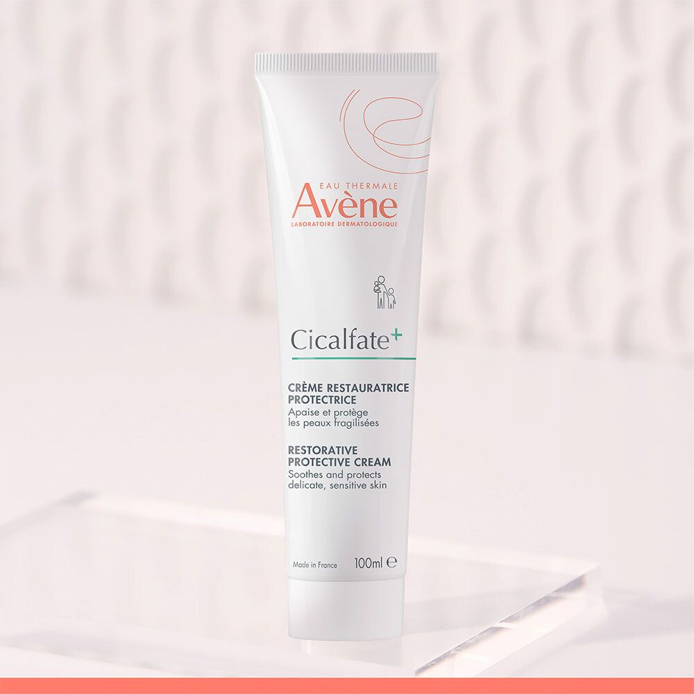 Tube blanc Avene Cicalfate+ crème. Texte et logo. Sur verre.