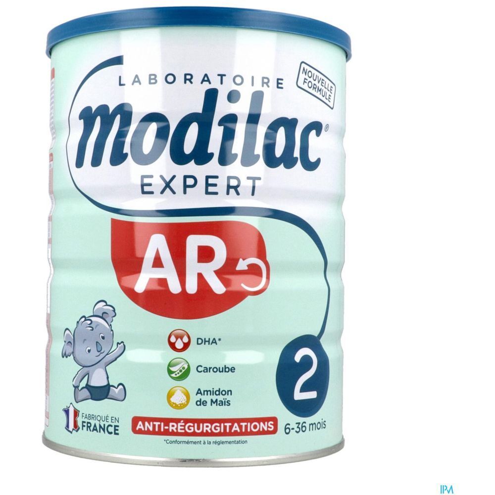 Boîte verte claire avec couvercle bleu. Inscription 'modilac EXPERT AR'. Contient 'DHA', 'Caroube', 'Amidon de Mais'. Recommandé pour les 6-36 mois.