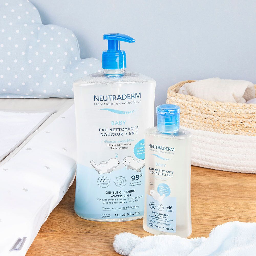 Zwei Neutraderm Baby Reinigungswasser-Flaschen. Eine große und eine kleine. Auf einem Wickeltisch. Baby-Accessoires.