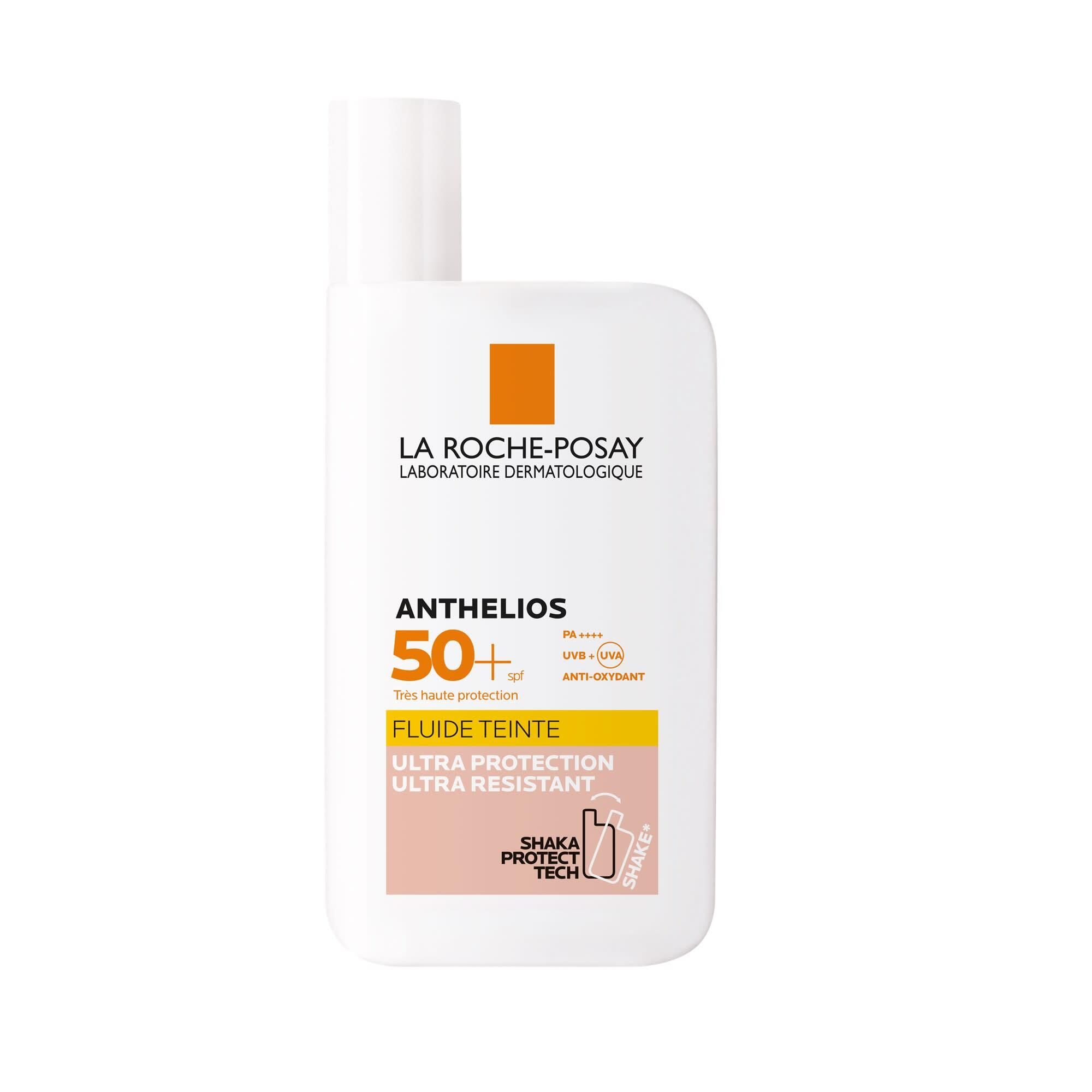 Fluide solaire teinté SPF 50+. Flacon blanc, accent orange. Texte: Anthelios, Fluide Teinté, Ultra Protection.