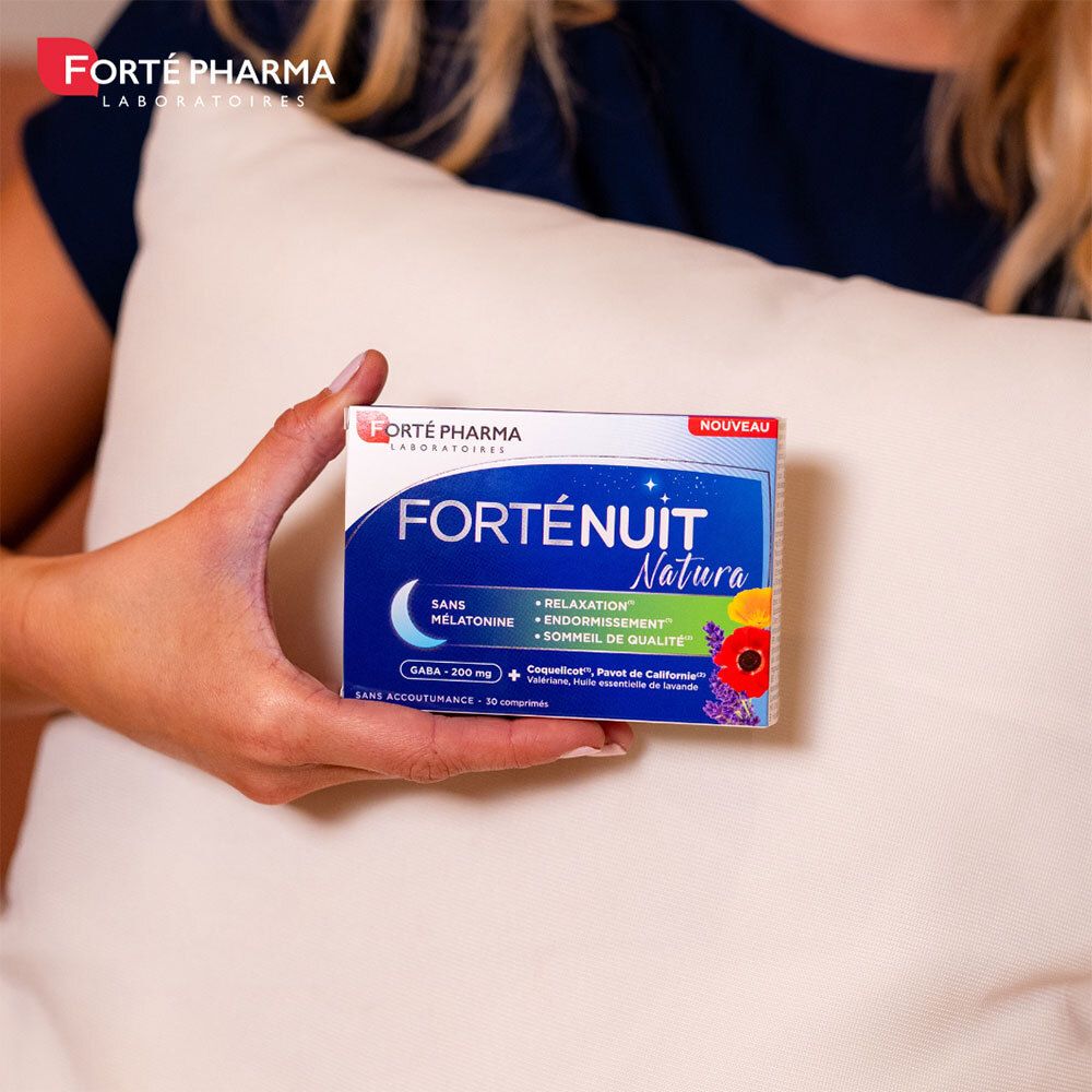 Femme tenant une boîte. Boîte: Forté Pharma, Forténuit Natura, sans mélatonine, relaxation, endormissement, qualité du sommeil.
