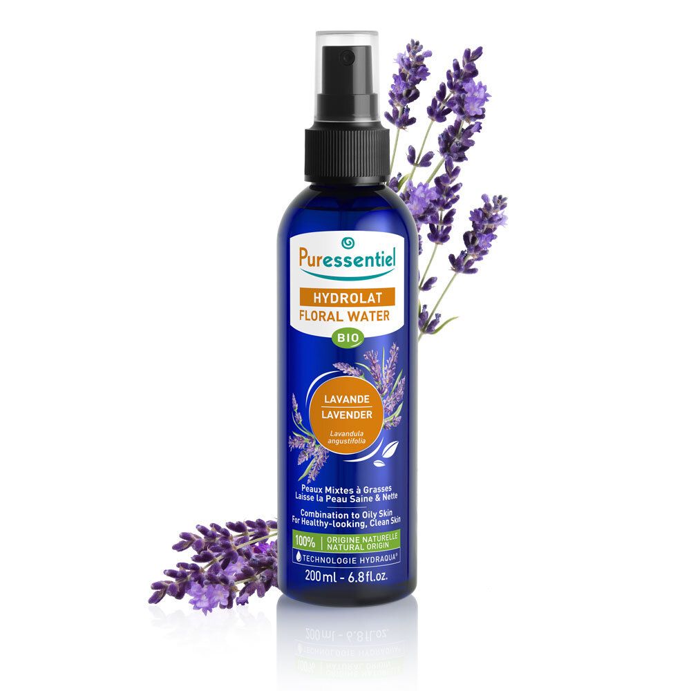 Flacon bleu foncé avec vaporisateur et fleurs de lavande. Étiquette avec nom du produit.