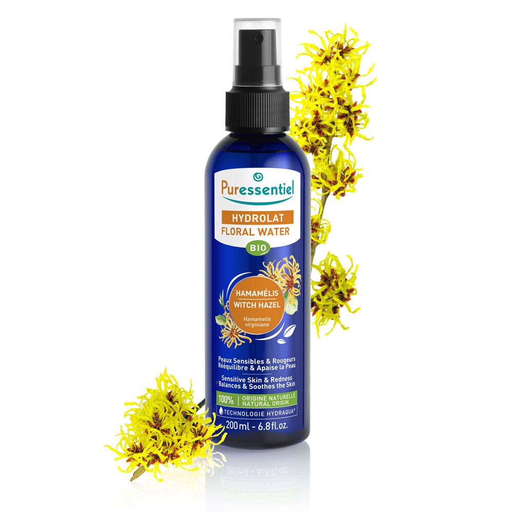 Blauwe Flasche mit Zerstäuber und gelben Blüten. Aufschrift: Puressentiel, Hydrolat Floral Water, Hamamelis, 200ml.