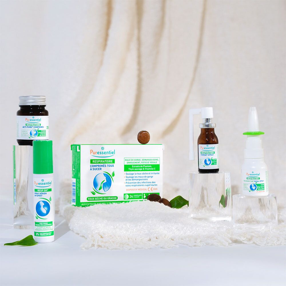Spray nasal avec bouchon vert sur une table. Une personne en arrière-plan. Texte: PURESSENTIEL RESPIRATOIRE.