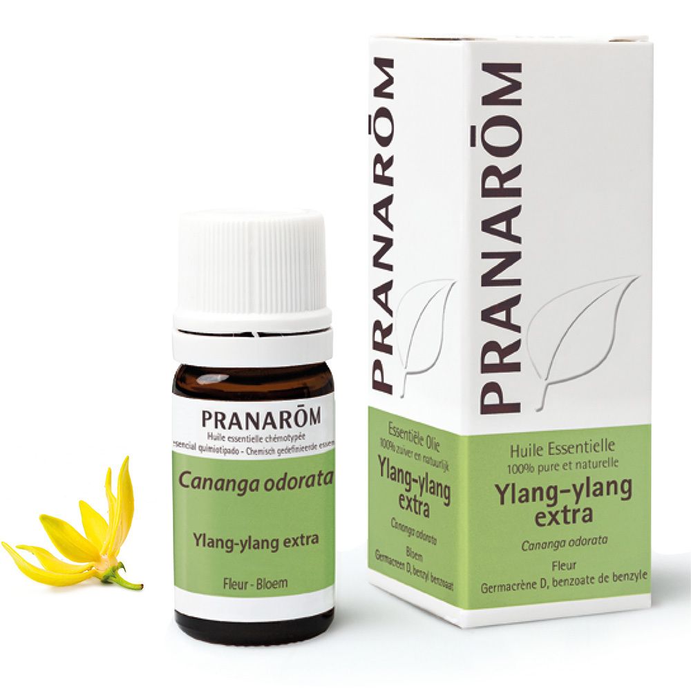 Flacon en verre brun avec bouchon blanc et étiquette. Boîte avec informations produit. Fleur jaune.