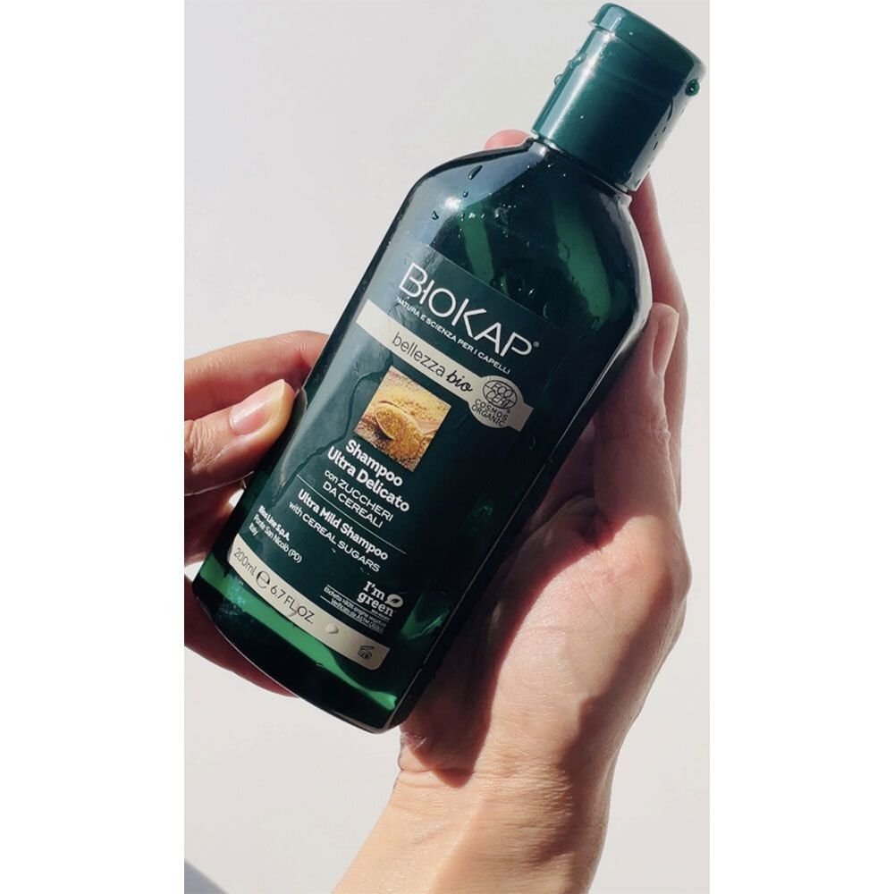 BIOKAP Bellezza Bio Shampooing Ultra Délicat. Bouteille verte dans la main. Avec texte.