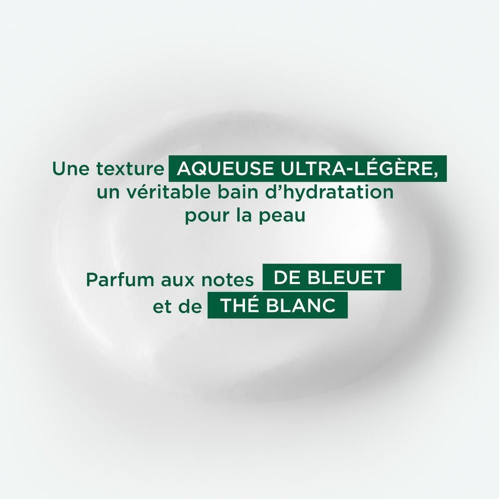 Fond blanc avec texte: Une texture aqueuse ultra-légère, un véritable bain d'hydratation pour la peau. Parfum aux notes de bleuet et de thé blanc.