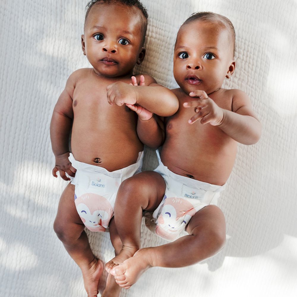 Deux bébés avec des couches. Inscription : Biolane. Illustration de singe. Taille de couche 3.