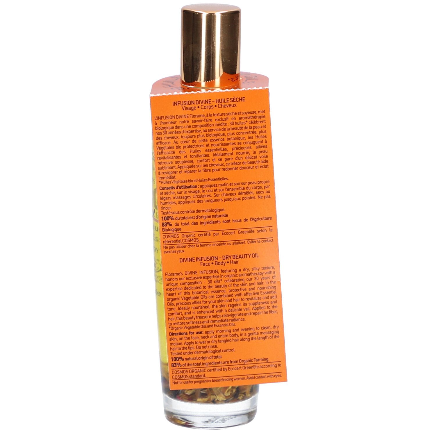Flacon en verre avec bouchon doré et étiquette. Contient un liquide avec des fleurs. Étiquette avec texte. Inscription : Infusion Divine, Huile Seche.