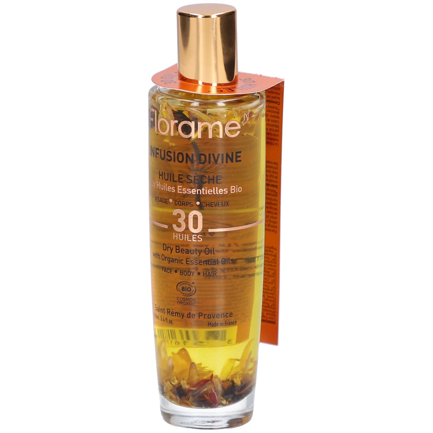 Flacon en verre avec bouchon doré et étiquette. Contient un liquide avec des fleurs. Inscription : Infusion Divine, Huile Seche.
