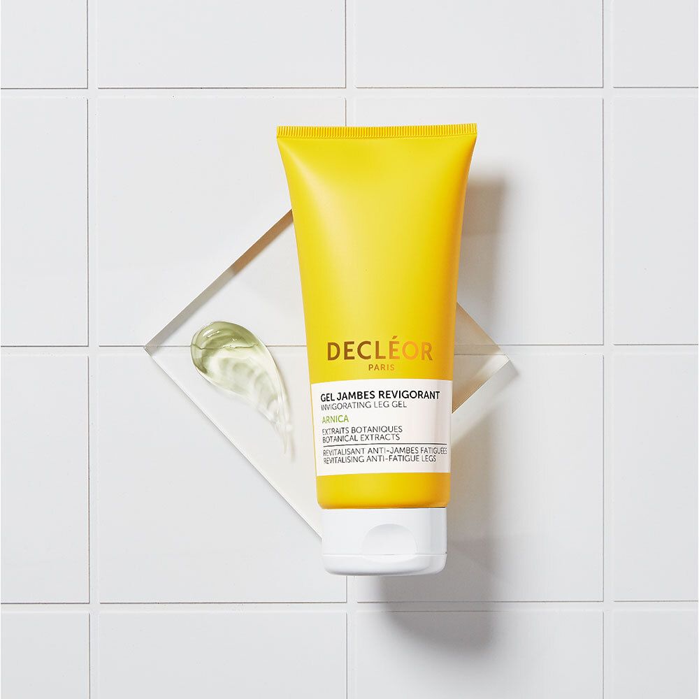 Tube de gel sur fond blanc. Tube jaune avec bouchon blanc. DECLÉOR PARIS. Gel Jambes Revigorant. Tache de gel.