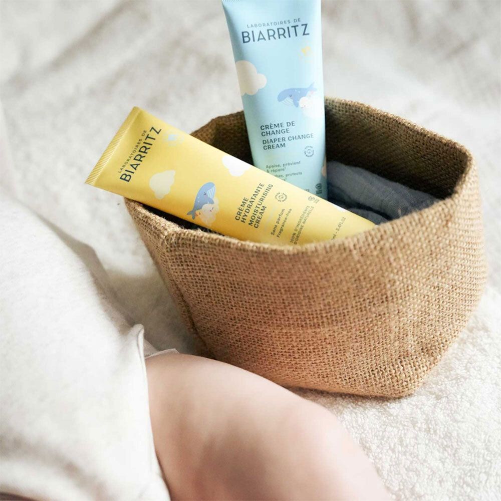 Zwei Tuben in einem Korb. Aufschrift: Laboratoires de Biarritz, Crème Hydratante, Crème de Change, Diaper Change Cream.