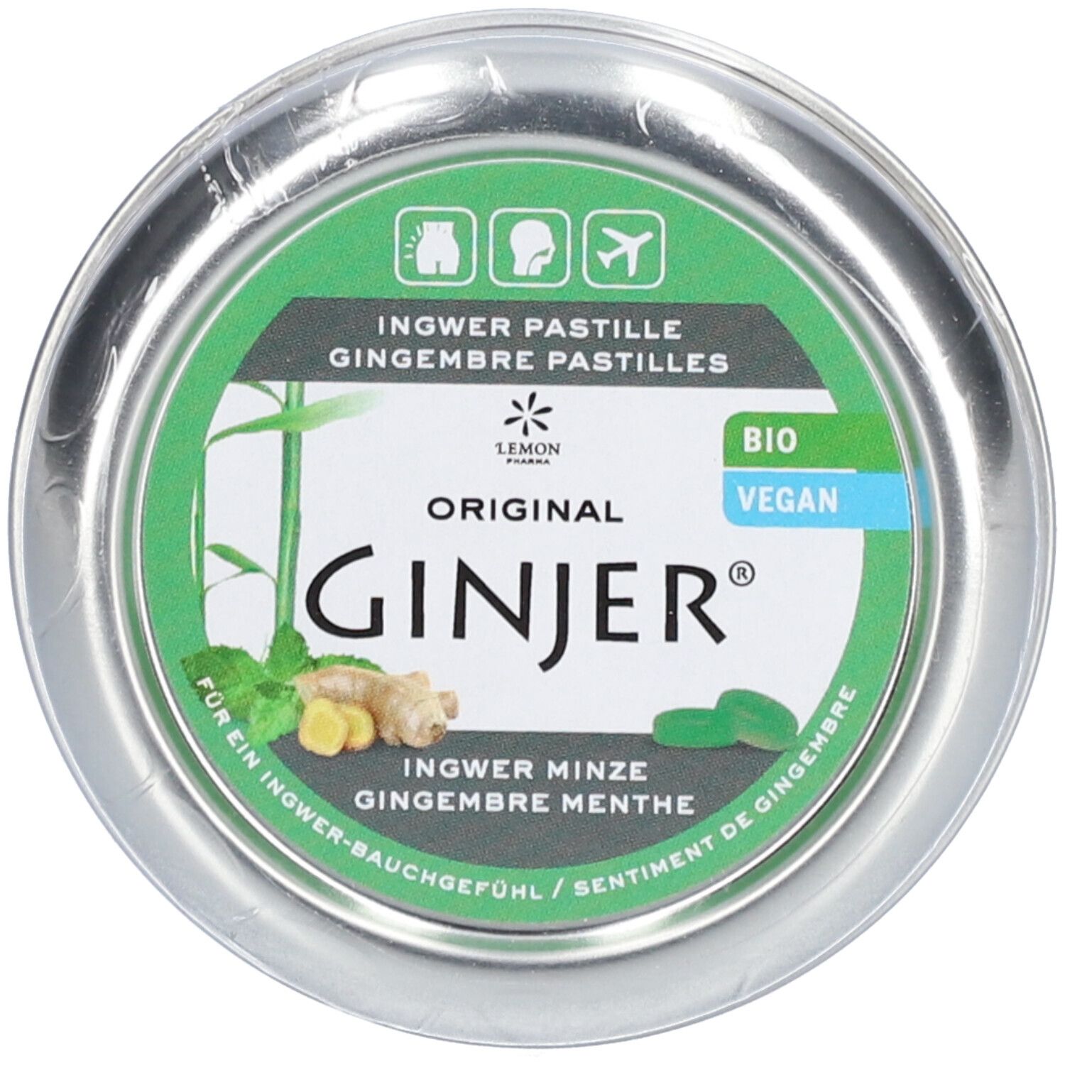 Boîte ronde avec étiquette verte. Logo "GINJER", illustrations de gingembre et menthe. Labels "BIO" et "VEGAN".