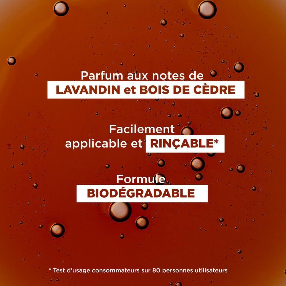 Nahaufnahme von brauner Flüssigkeit mit Blasen. Text: Parfum aux notes de Lavandin et Bois de Cèdre. Formule Biodégradable.