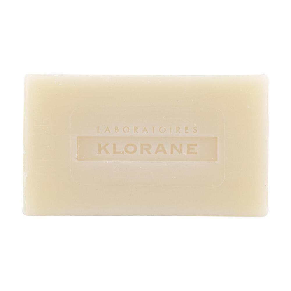 Rechteckige, cremefarbene Seife mit eingeprägtem Schriftzug KLORANE. Aufschrift: LABORATOIRES.