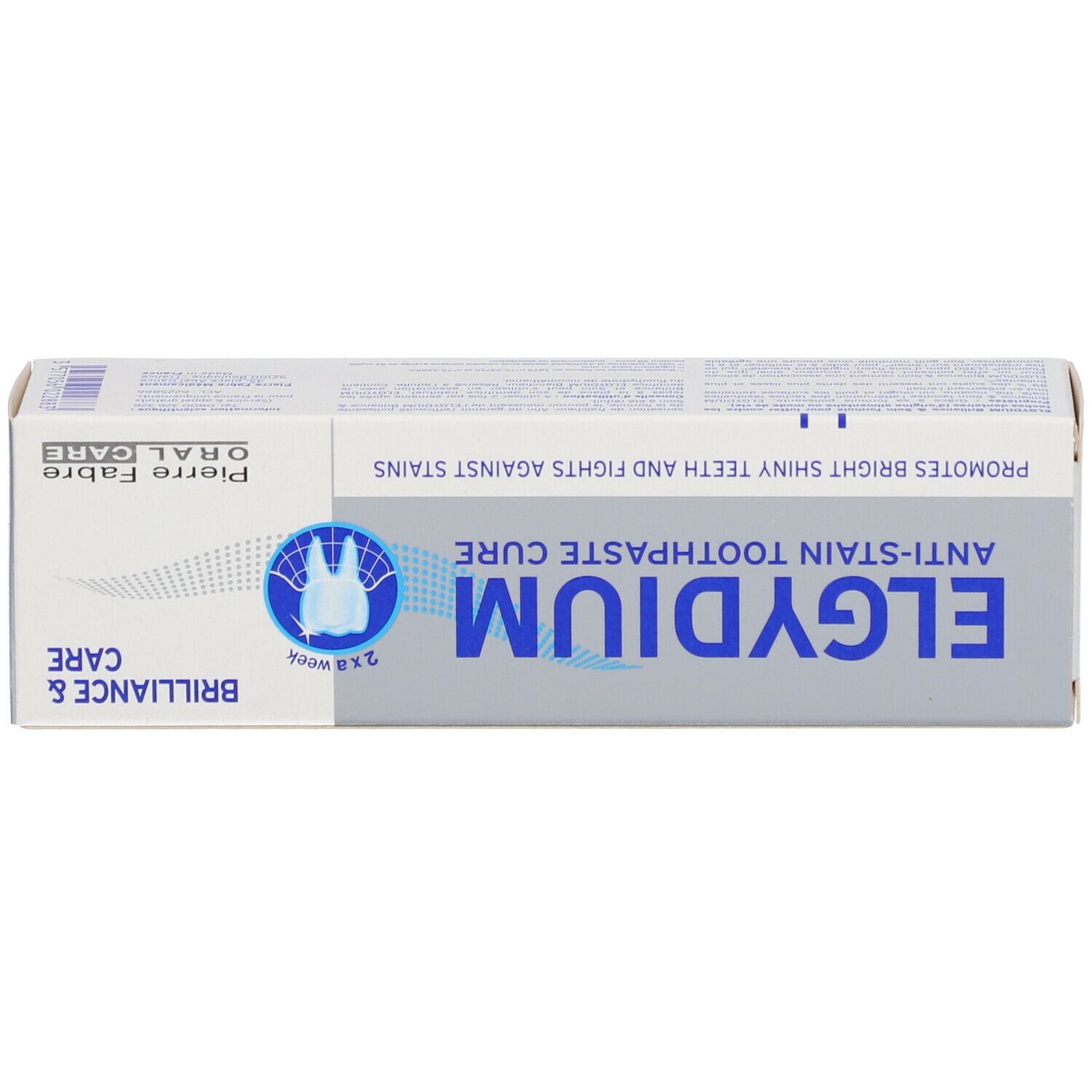 Boîte, vue de dessus. ELGYDIUM, Cure Dentifrice Anti-Tache. Texte bleu, fond gris.