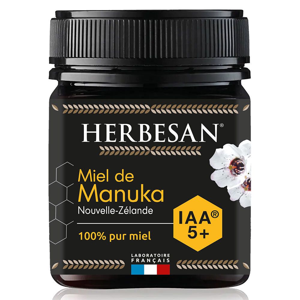 Pot en verre foncé, couvercle noir. Inscription HERBESAN, Miel de Manuka IAA 5+. Fleur blanche et logo IAA 5+ jaune.