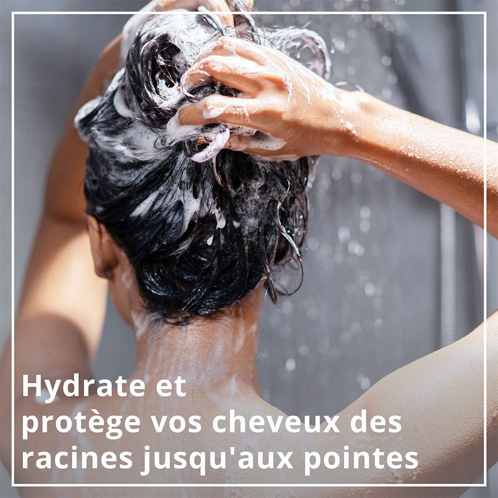 Person wäscht Haare mit Shampoo. Text: Hydrate et protège vos cheveux des racines jusqu'aux pointes.