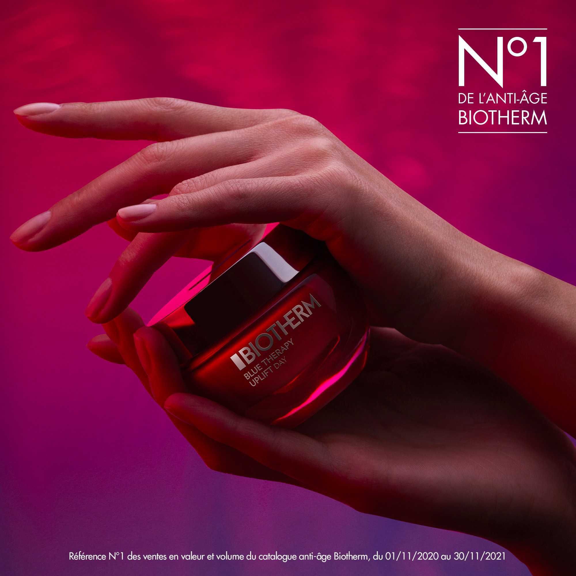 Hände halten einen roten Tiegel. BIOTHERM-Logo sichtbar. Hintergrund: Lila und Rot.