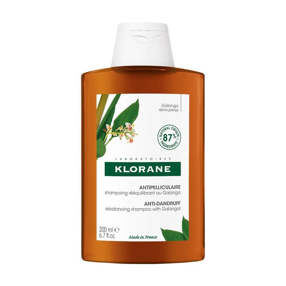 Flacon marron avec bouchon blanc. Étiquette avec nom du produit, ingrédients et logo. 87% ingrédients naturels.