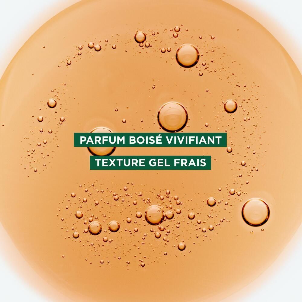 Gros plan d'un liquide jaune avec des bulles. Texte: 'PARFUM BOISÉ VIVIFIANT' et 'TEXTURE GEL FRAIS'.