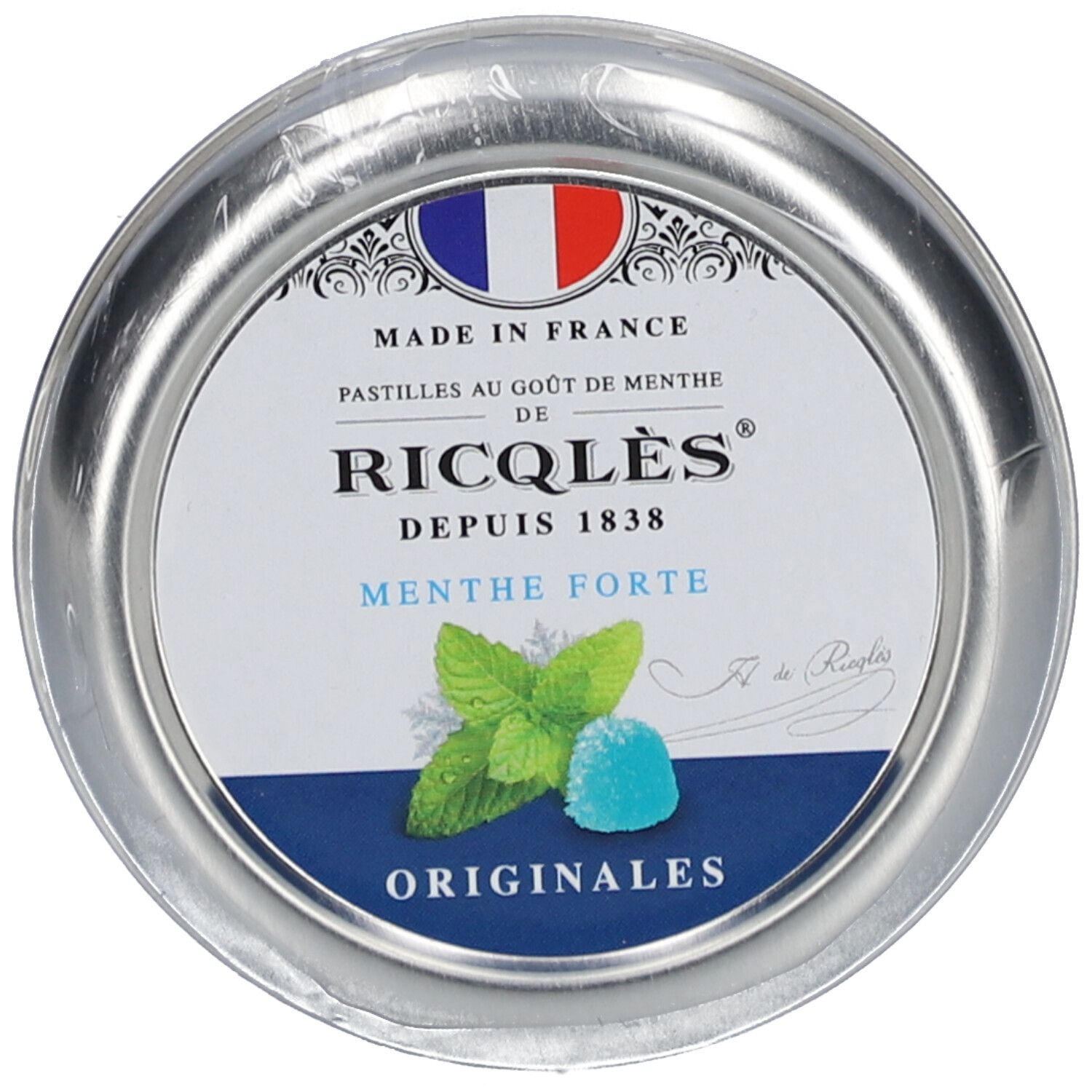 Boîte ronde de pastilles. Couvercle avec logo, drapeau français et texte 'Ricqlès'. 'Menthe Forte' et illustration de feuilles de menthe.