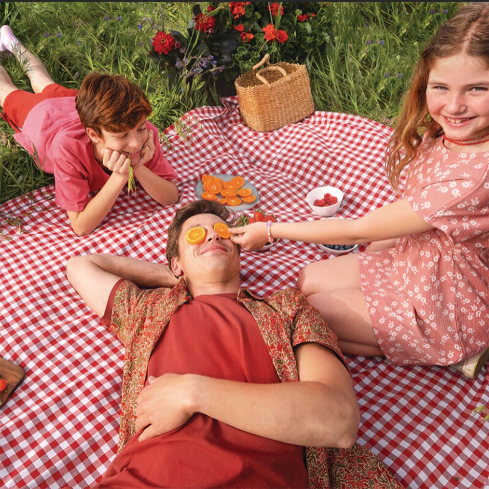Familie auf Picknickdecke. Keine Produkte sichtbar.