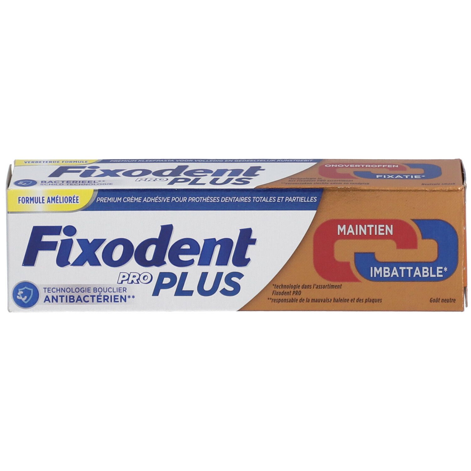 Emballage de crème adhésive pour prothèses dentaires. Boîte marron avec inscription: Fixodent Pro Plus. Accents jaunes et bleus.