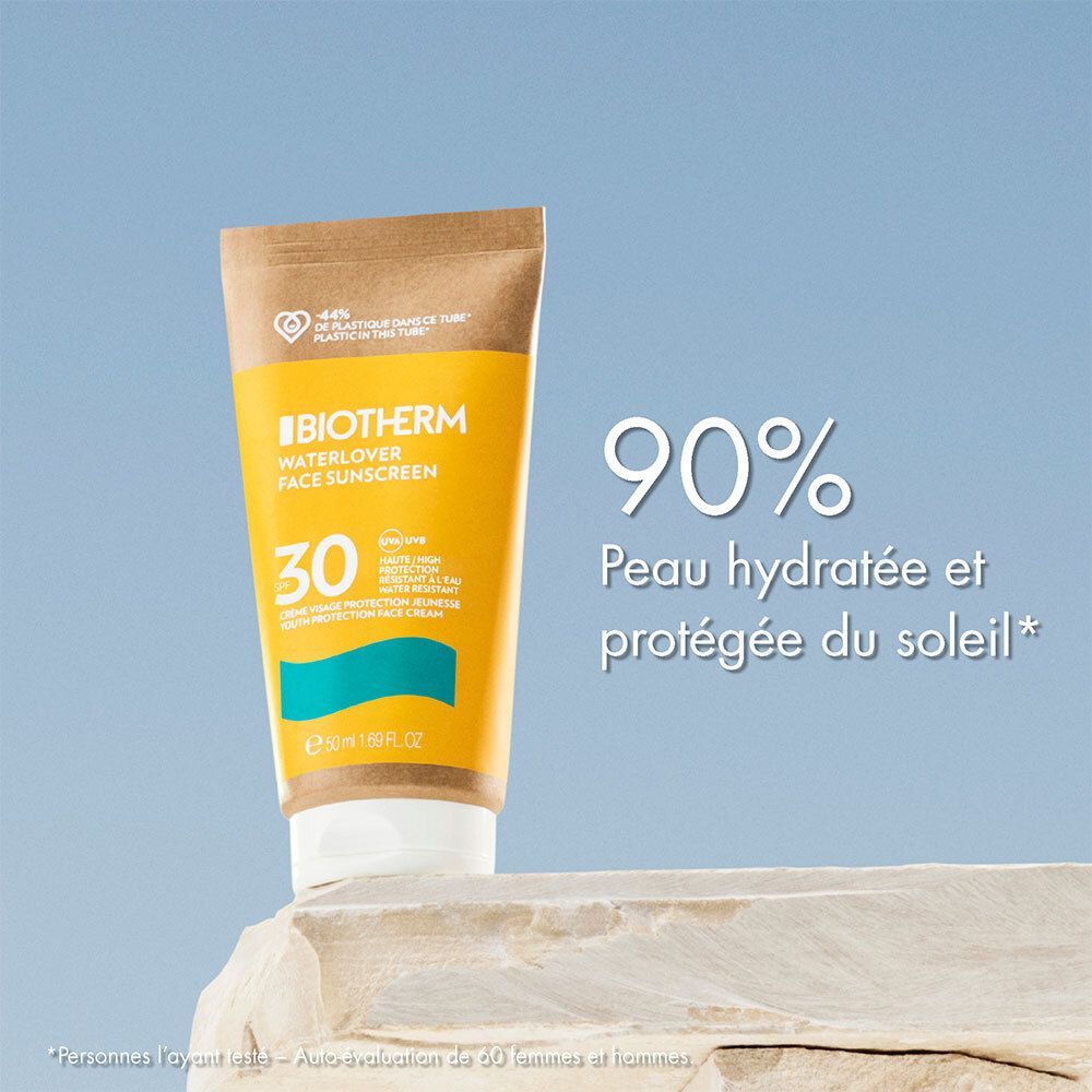 Gelbe Tube Sonnencreme auf Felsen. Aufschrift: BIOTHERM WATERLOVER FACE SUNSCREEN SPF30. Text: 90% hydratisierte Haut.