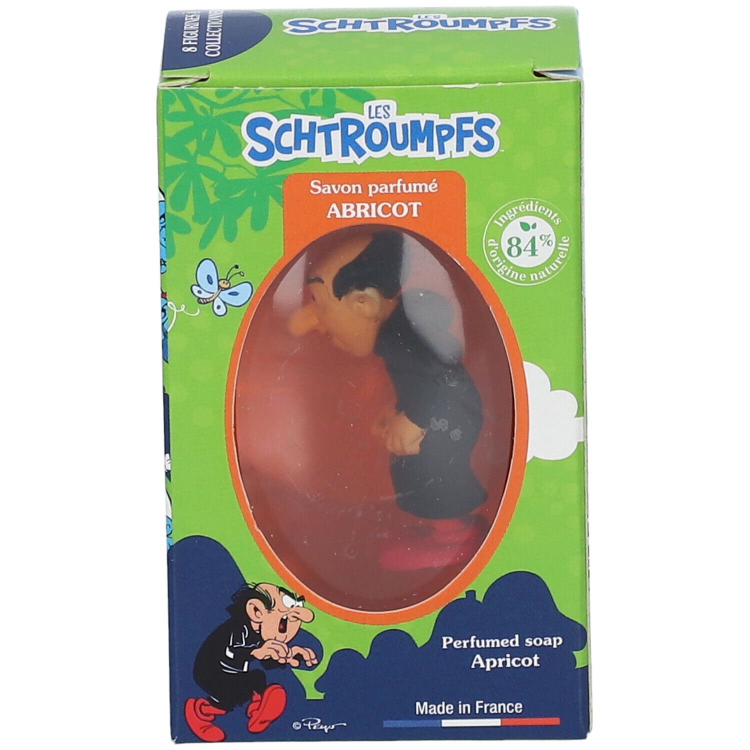 Seife mit Gargamel-Figur in Schachtel. Schachtel mit grünem Hintergrund, Text und Illustrationen. Sichtbares Produkt durch Fenster.