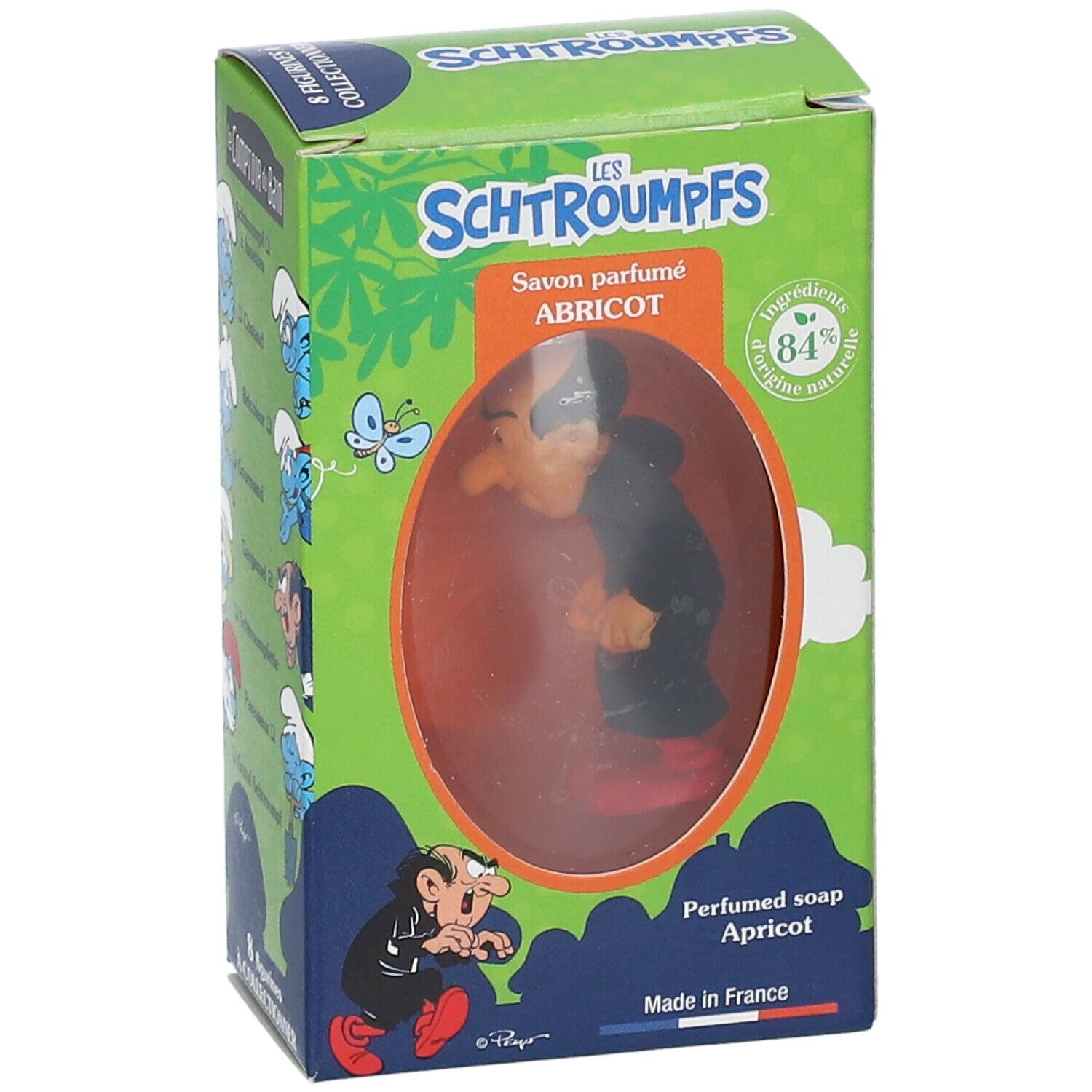 Seife mit Gargamel-Figur in Schachtel. Schachtel mit grünem Hintergrund, Text und Illustrationen. Sichtbares Produkt durch Fenster.