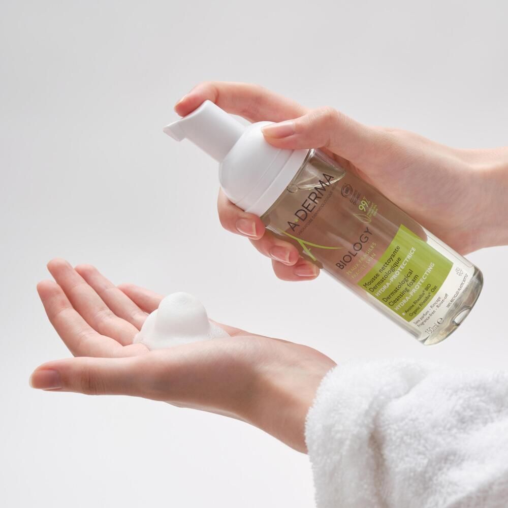 Mains tenant un flacon de mousse nettoyante A-DERMA BIOLOGY, mousse sur la main.