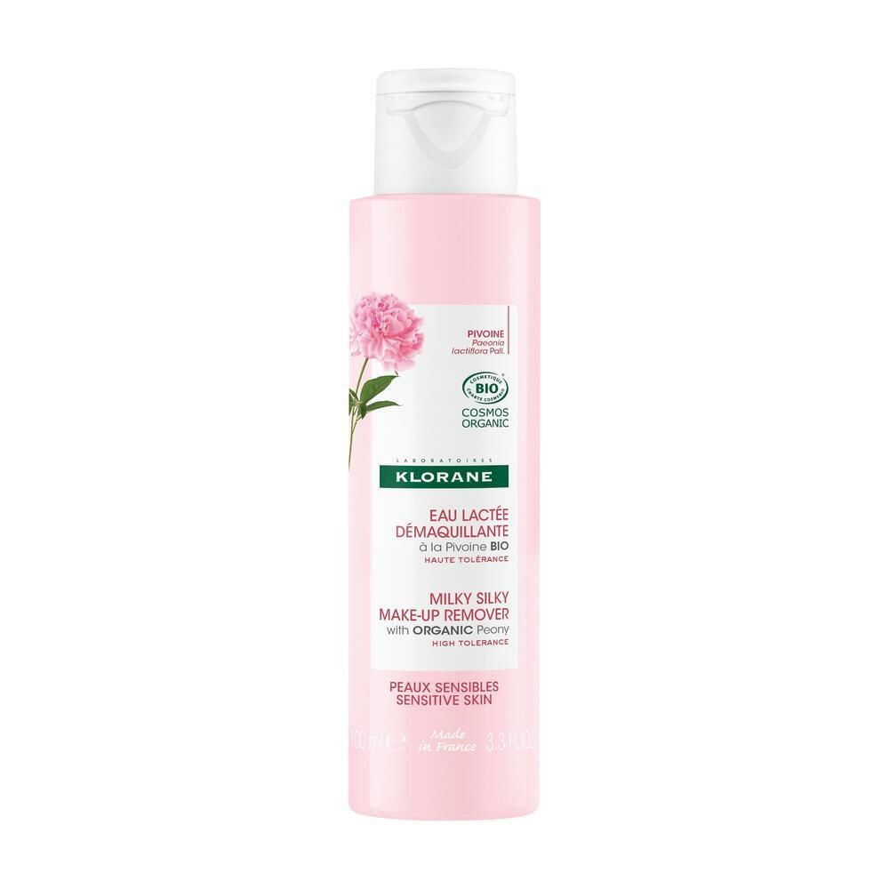 Flacon rose avec bouchon blanc. Inscription: KLORANE, Eau lactée démaquillante, Peaux sensibles. Illustration de pivoine.