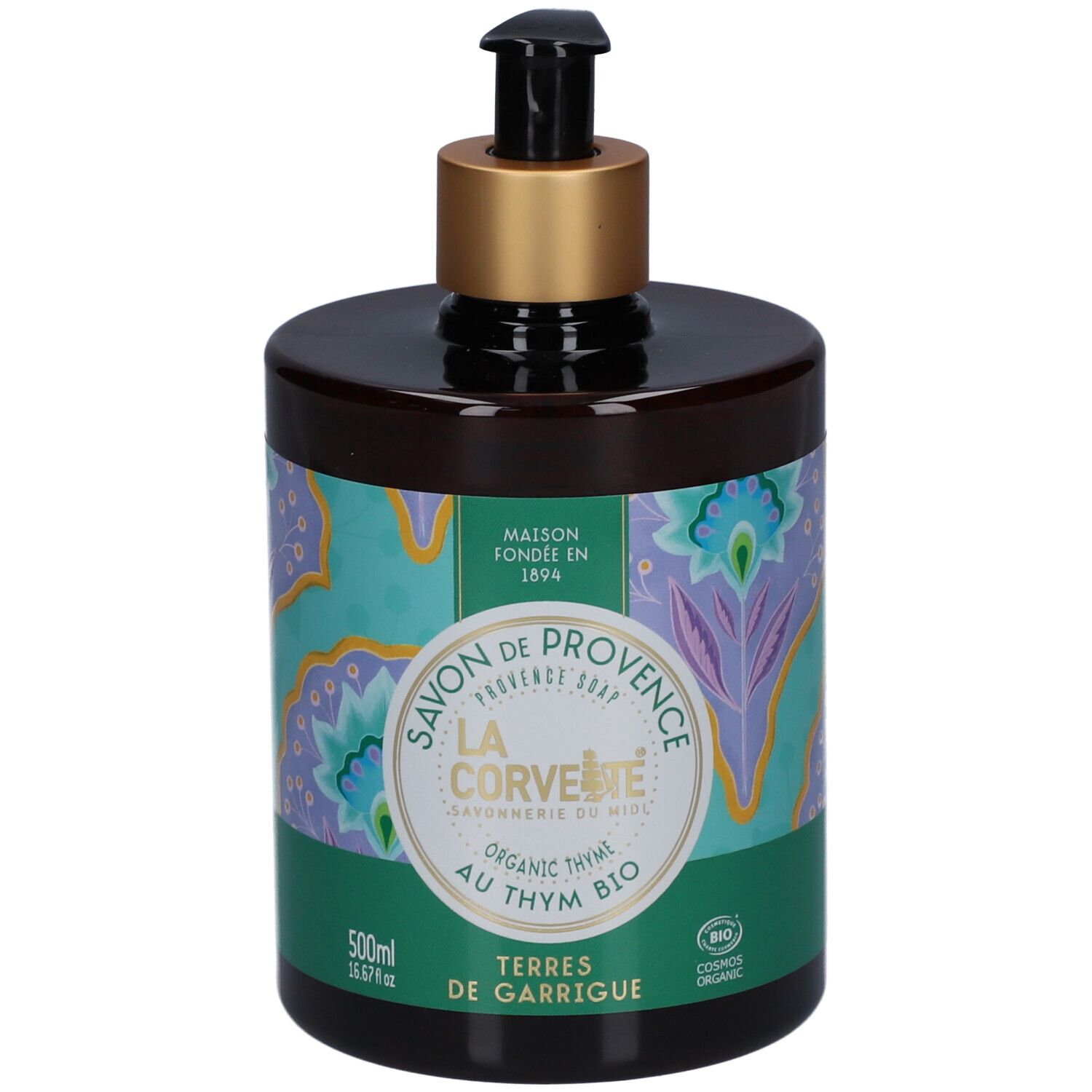 Flacon de savon brun avec pompe noire et bague dorée. Étiquette vert-turquoise avec motif floral et texte.