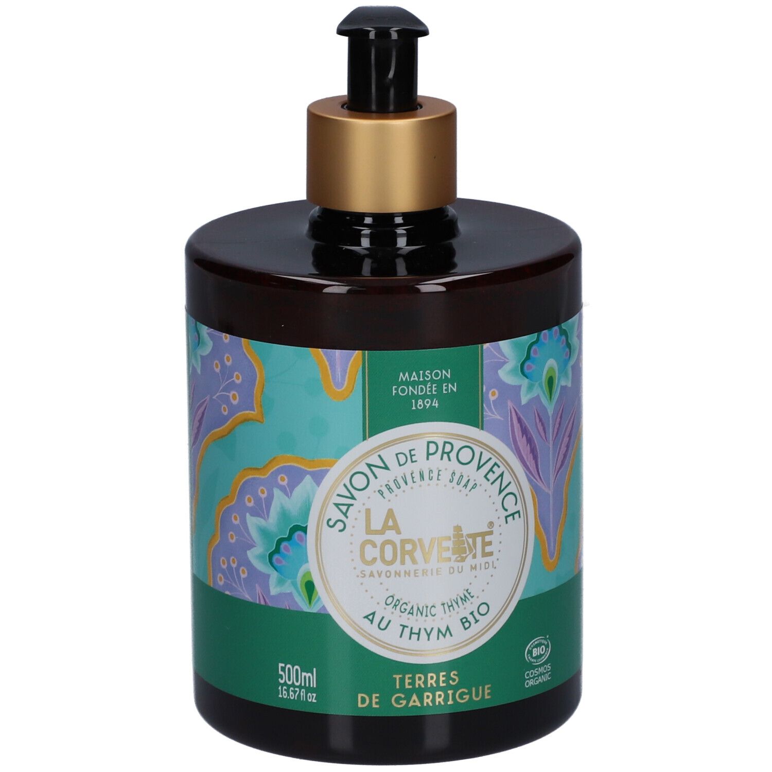 Flacon de savon brun avec pompe noire et bague dorée. Étiquette vert-turquoise avec motif floral et texte.