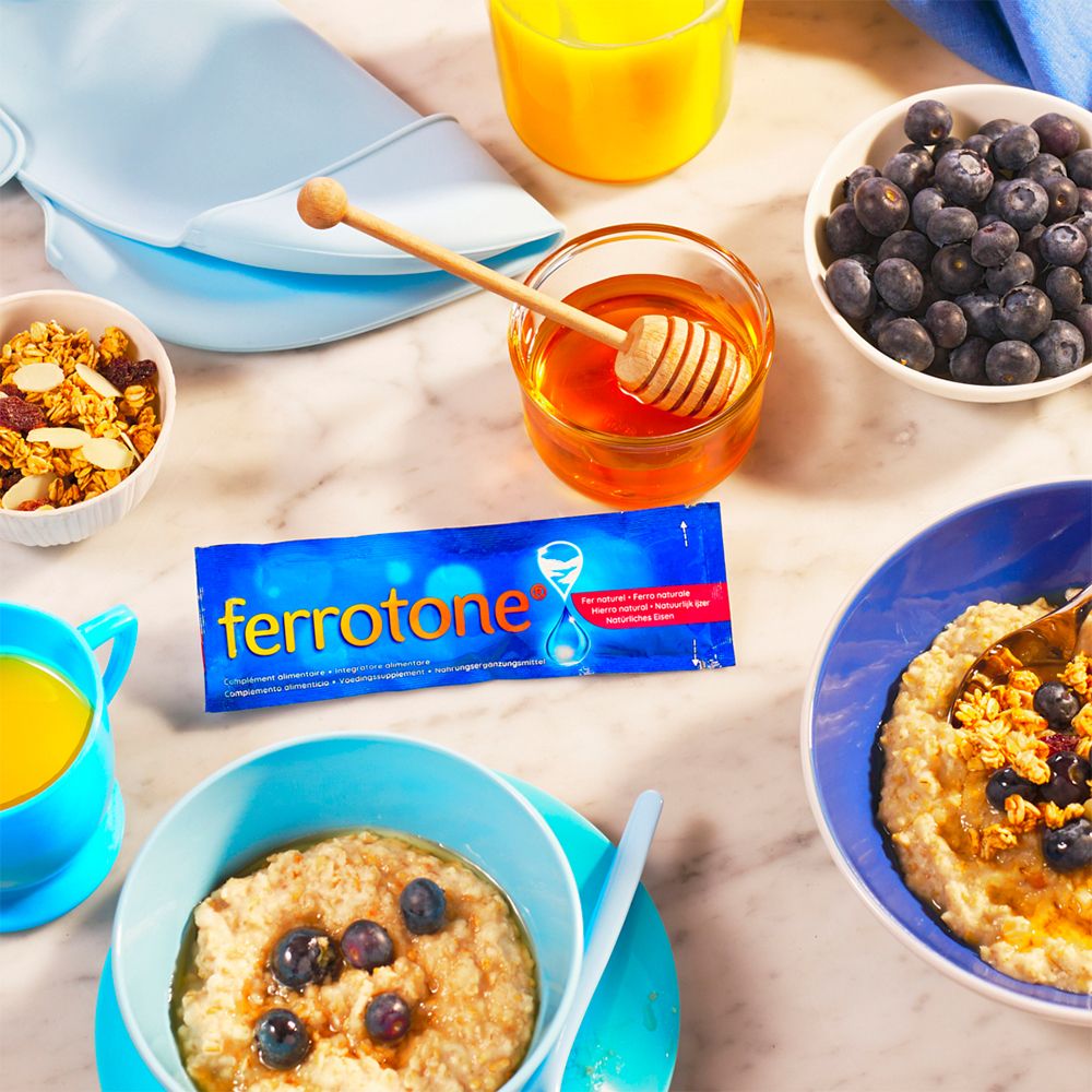 Paquet ferrotone®, flocons d'avoine, myrtilles, miel, table de petit-déjeuner. Bols et tasse bleus.