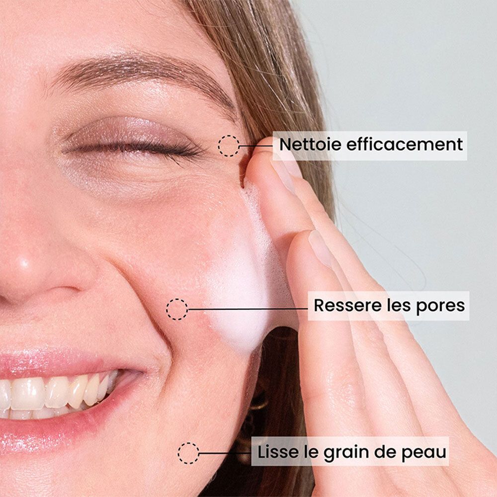 Gros plan d'un visage nettoyé à la mousse. Texte: Nettoie efficacement, resserre les pores, lisse le grain de peau.