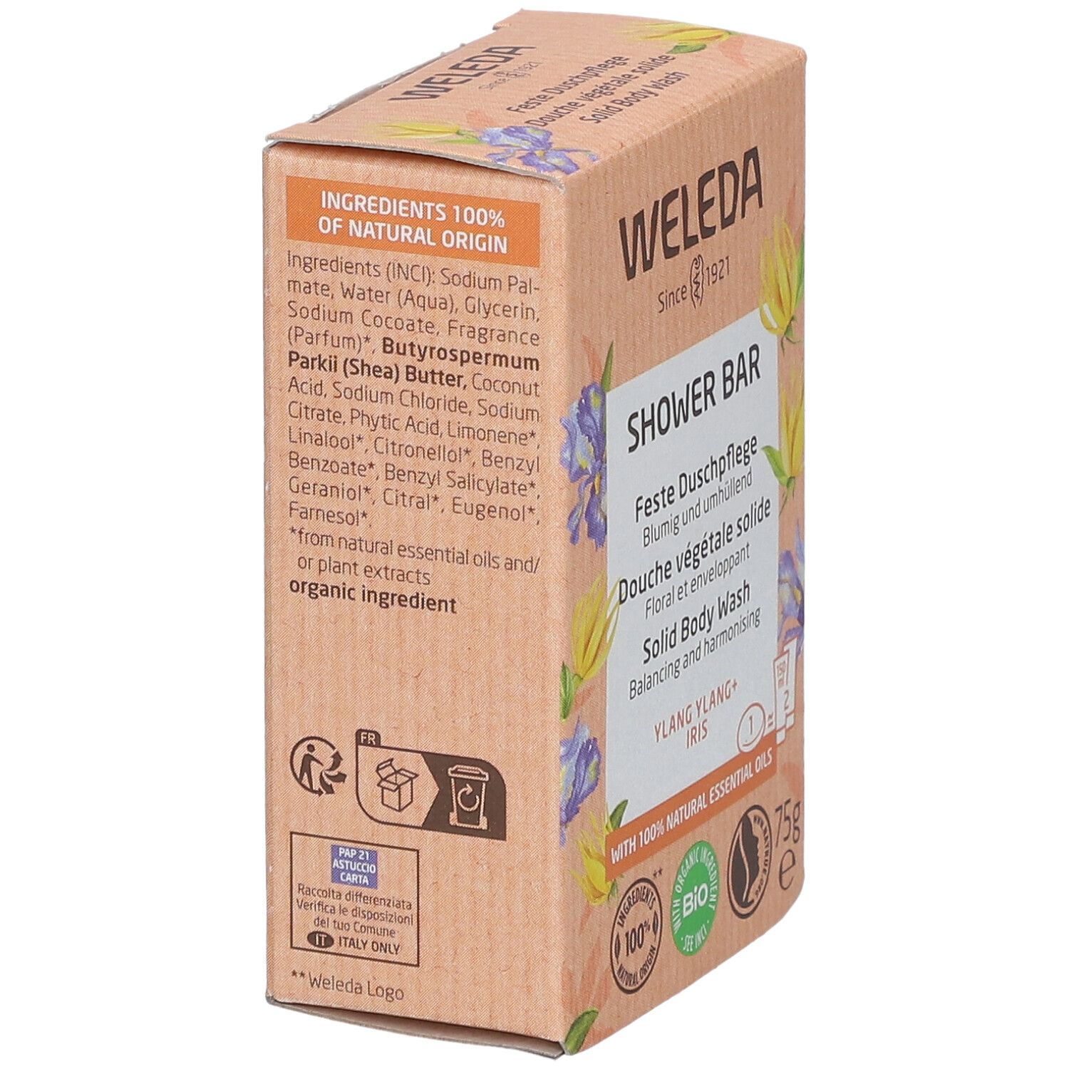 Boîte avec ingrédients et logo WELEDA. Inscription : SHOWER BAR, Ylang Ylang + Iris. Avec 100% huiles essentielles naturelles. 75g.