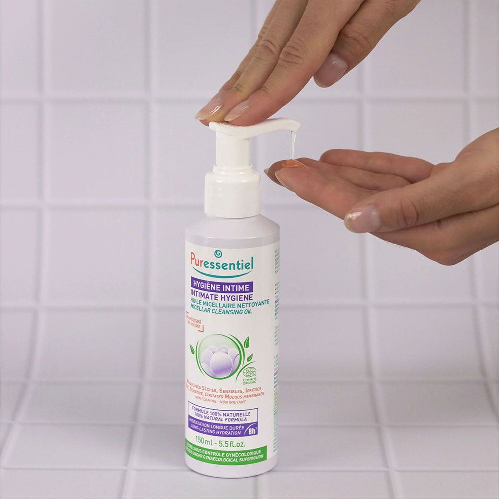 Mains pressant du liquide d'un flacon blanc avec pompe. Inscription : Puressentiel, Hygiène Intime.