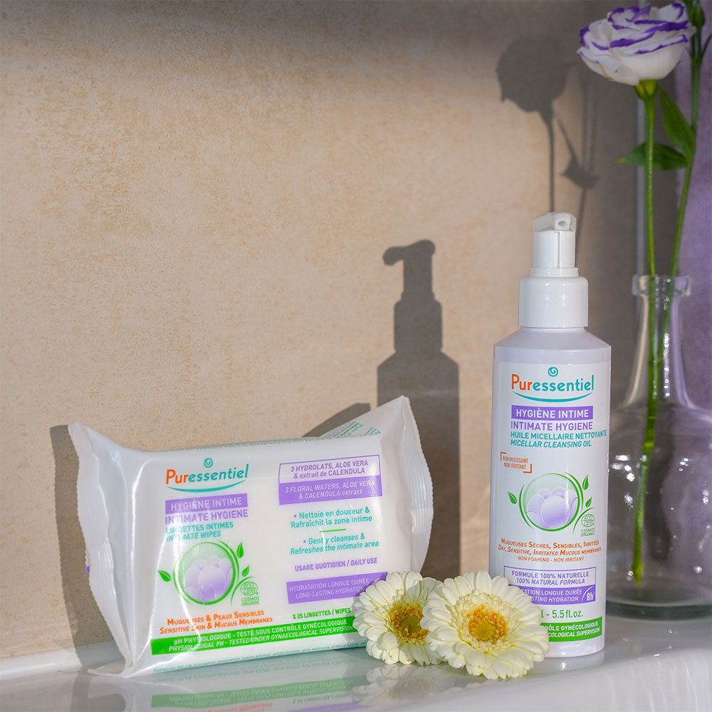 Flacon blanc avec pompe, à côté lingettes et une fleur. Inscription : Puressentiel, Hygiène Intime.
