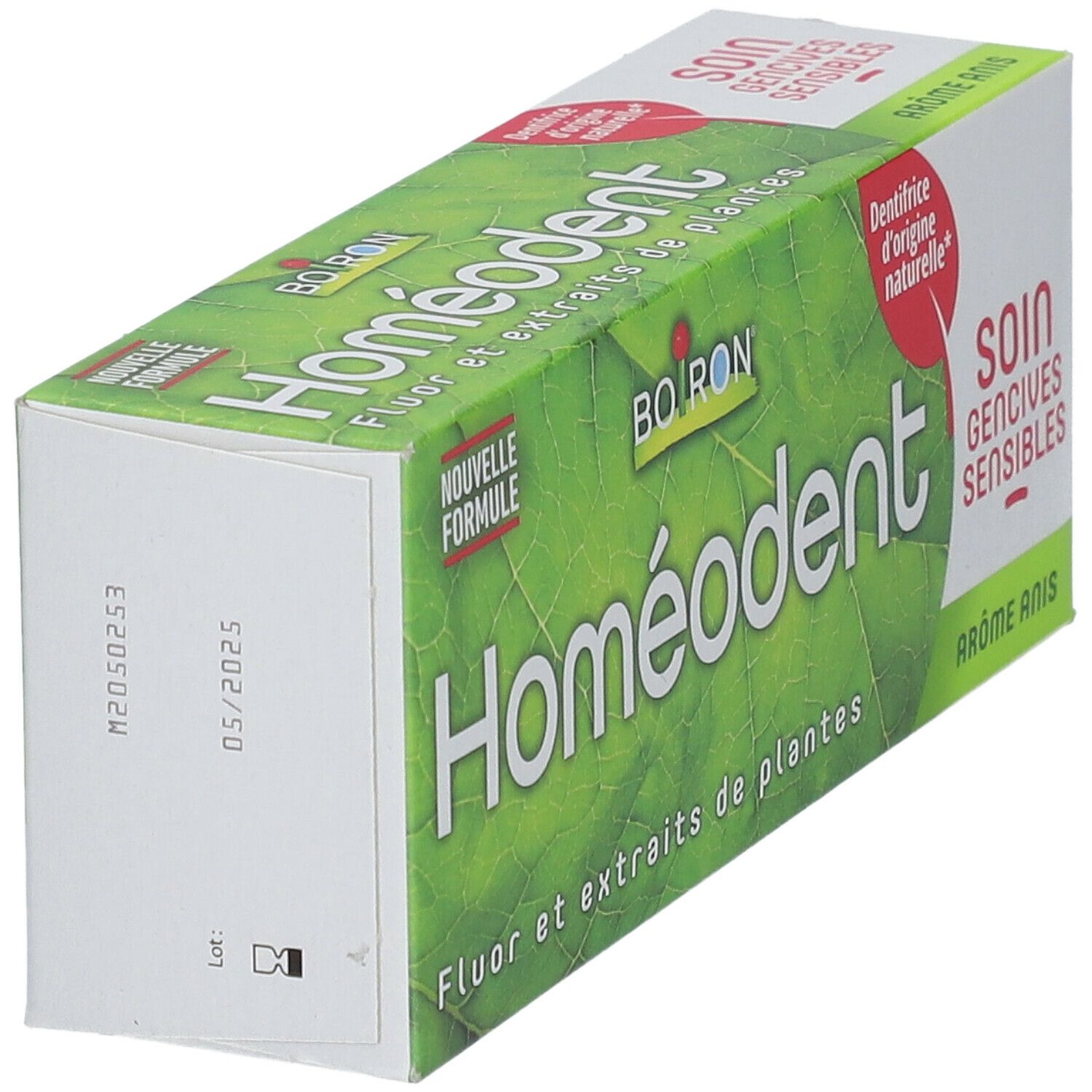 Homéodent-Verpackung, grüne Blätter, Text: Fluor und Pflanzenextrakte, Soin gencives sensibles, Aromatisierter Anis, Winkelansicht.