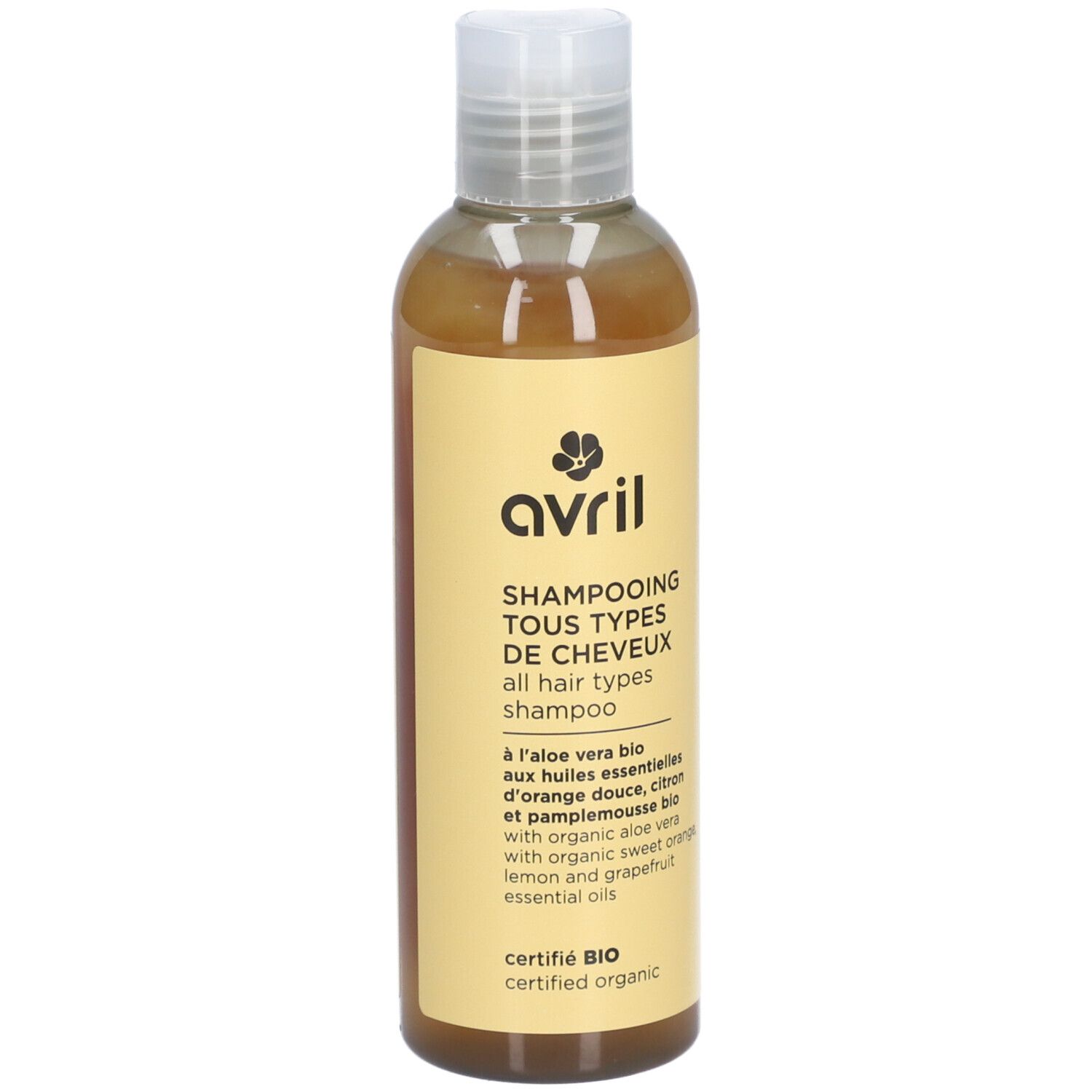 Flacon de shampooing avec étiquette jaune. Texte: Avril, Shampooing Tous Types de Cheveux, certifié Bio.