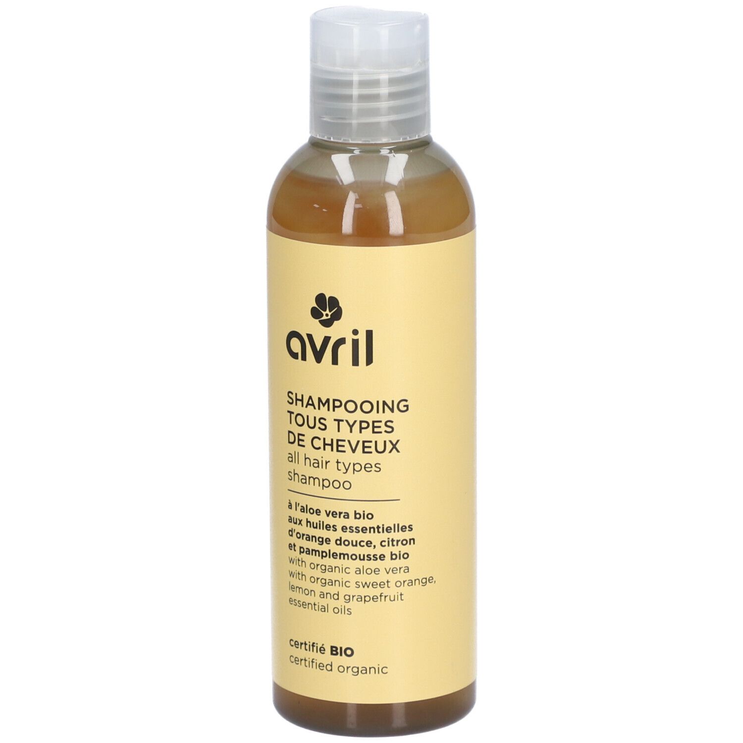 Flacon de shampooing avec étiquette jaune. Texte: Avril, Shampooing Tous Types de Cheveux, certifié Bio.